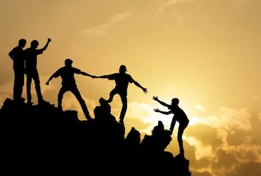 Group of hikers helping each other climb a mountian